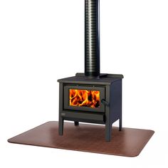 a stove with a wood burning in it on top of a wooden floor mat next to an oven