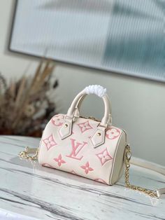 Creamy white with pink silk screen printing This Speedy Bandoulière 20 handbag is made of Monogram Empreinte leather, which presents the Monogram pattern through embossing and printing processes. The rolled leather handle, padlock, and rounded shape are inspired by the Speedy duffle bag, introduced in 1930. Dimensions: 20.5 x 13.5 x 12 cm Louis Vuitton Yayoi Kusama, Louis Vuitton Speedy Bandouliere, Lv Speedy, Louis Vuitton Capucines, Lv Purse, Lv Bags, Lv Handbags, Urban Street, Lv Belt