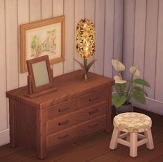 a small wooden dresser sitting next to a flower pot on top of a hard wood floor