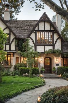 a large house with lots of windows and plants in the front yard, along with a walkway