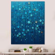 an abstract painting with blue circles on the wall above a console table in a living room