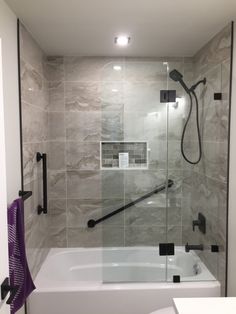 a white bath tub sitting next to a walk in shower