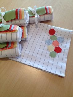 four folded quilts sitting on top of a wooden table