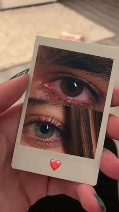 a woman holding up a card with an image of her eye and heart on it