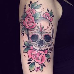 a woman's arm with a skull and roses on it