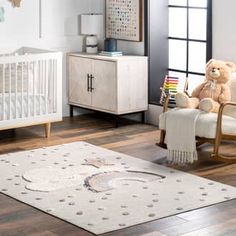 a baby's room with a crib, rocking chair and teddy bear on the floor