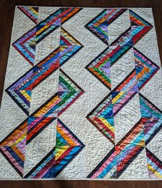 a multicolored quilt on a wooden floor