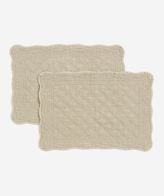 two white placemats sitting next to each other