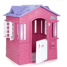 a pink doll house with a door and windows on the outside, inside is a white door