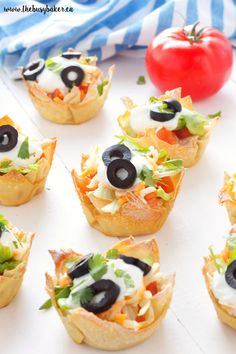 mexican taco dip wonton cups with black olives and lettuce on top