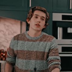 a young man standing in front of a kitchen counter