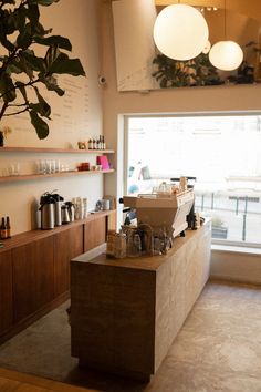 the inside of a coffee shop with lots of counter space and hanging lights above it