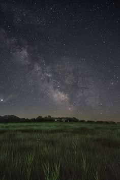 the night sky is filled with stars and green grass