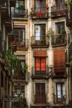 an old building with many balconies and plants growing on the balconys in it