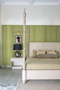 a white bed sitting in a bedroom next to a green painted wall on the other side