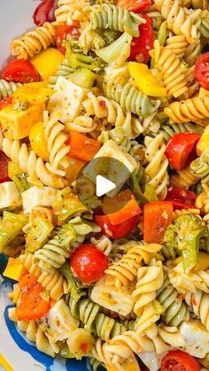 a colorful pasta salad with tomatoes, broccoli and peppers