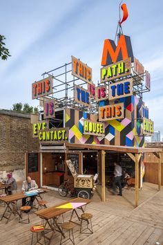 the building has many colorful signs on it's sides and is made out of wood