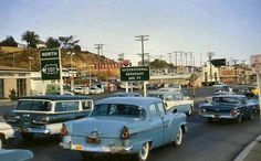 old cars are driving down the road in traffic