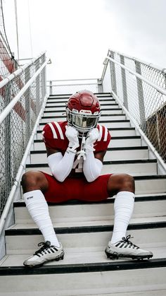 a football player is sitting on the stairs with his foot propped up against his face