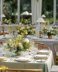 the table is set with white and yellow flowers