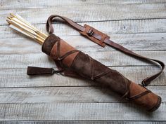 an umbrella that is sitting on top of a wooden floor with two arrows in it