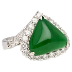 Cabochon Cut Kite/Triangle Shaped Type A Jadeite Jade in a 3-prong 18k white gold ring setting. Featuring a prong-set Jade centerpiece embraced by a dazzling halo of diamond side-stones, this captivating masterpiece exudes timeless elegance and sophisticated glamour. Item Details: - Metal: 18K White Gold - Weight: 8.0 Grams - Setting: Prong - Size: 6.5 (adjustable) - Ring Face: 2.7 x 2.2 cm Center Stone Details: - Stone: Jadeite Jade - Type: A - Color: Green - Cut: Cabochon Side Stone Details: - Tiny Diamond Earrings, Jade Earrings, Tiny Diamond, Ring Setting, White Gold Ring, Multi Stone Ring, Triangle Shape, Diamond Halo, Types Of Rings