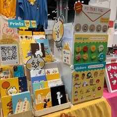 a bunch of cartoon magnets on display at a trade show or exhibition with price tags and stickers attached to them