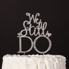 a cake with the words we still do written on it in white frosting and surrounded by sparkles