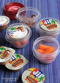 plastic containers filled with carrots and other food items on a blue striped tablecloth