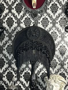 an ornate wall with black and white damask on it, including a clock in the center