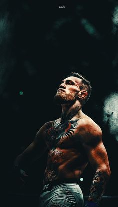 a man with tattoos standing in the dark