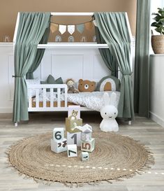 a baby's room is decorated in green and white colors with teddy bears on the floor