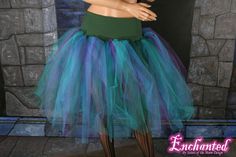 a mannequin dressed in a green and blue tutu skirt with black stockings