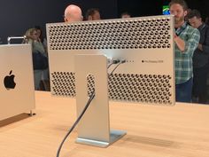 an apple computer is on display with people in the background