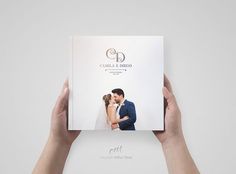 two hands holding up a wedding album with the cover open to show a photo of a bride and groom