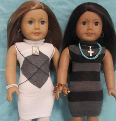 two dolls are standing next to each other on a blue cloth covered background, one is wearing a black and white dress