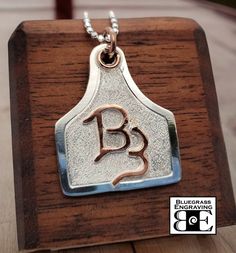 Made upon order - allow approx 4 week lead time. One sterling silver livestock ear tag pendant, features: - Your custom brand overlaid in brass, copper, or sterling silver (choose from drop-down box) - Nicely sized, measuring approx 1.25" width x 1.5" tall - Hangs from 18" chain - Handcrafted, hand engraved border and textured background - Please send us your brand image or drawing (clearly oriented) via an Etsy conversation Cow Ear Tag, Hand Engraved Jewelry, Livestock Branding, Cowgirl Bling Jewelry, Western Style Wedding, Cow Ears, Cattle Brands, Girl Western, Stock Show