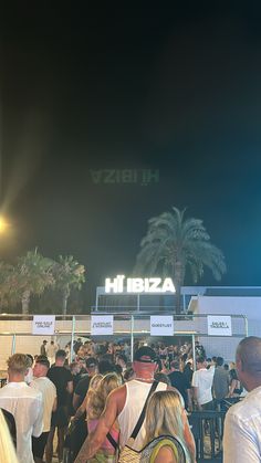 a crowd of people standing around in front of a building with a sign that reads azbii hi