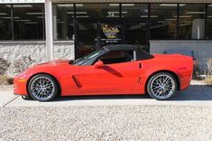 a red sports car parked in front of a building