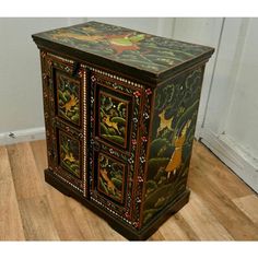 an ornately painted cabinet on the floor