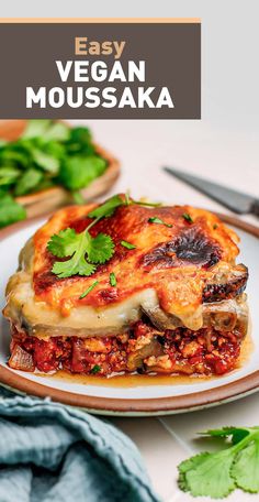 easy vegan moussaka on a white plate with green garnishes