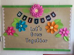 a bulletin board decorated with flowers and welcome sign for someone's new home, let's grow together