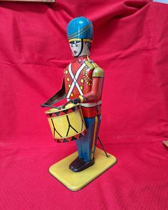 a toy soldier holding a drum on a red background