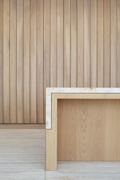 a wooden bench sitting in front of a wall with wood slats on the walls