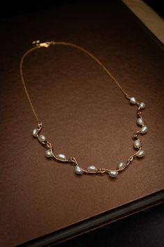 A handmade necklace with small freshwater pearls woven onto hammered gold-filled connector bars. Specifications: Length: 18 inches Materials: 18k Gold, Sterling Silver, Freshwater Pearls 90-97% Clear, High Luster/Nacre All orders come with a handwritten note, a sturdy cardboard drawer box, and a velvet pouch. Note: Each piece is hand-selected and hand-made to order. All of our natural materials vary in size and detailing, so each piece is uniquely your own. Made to order: ships within 2 to 4 wee Pearl Wire Necklace, Pearl With Gold Necklace, Edwardian Jewelry Necklaces, Jwellary Unique, Open Front Necklace, Unique Pearl Necklace, Small Gold Necklace, Vine Necklace, Pearl Gold Necklace