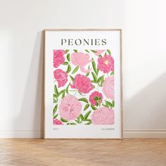 a pink flowered poster with the word peonies on it in front of a white wall