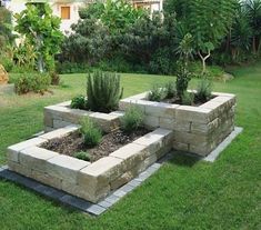 an outdoor garden with stone blocks and plants