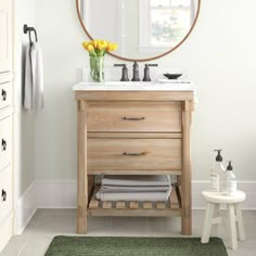 a bathroom with a round mirror above the sink and rug on the floor next to it