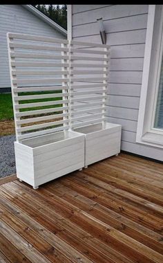 two white planters sitting on top of a hard wood floor next to a building