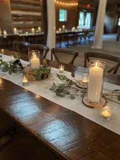 a long table with candles and greenery on it